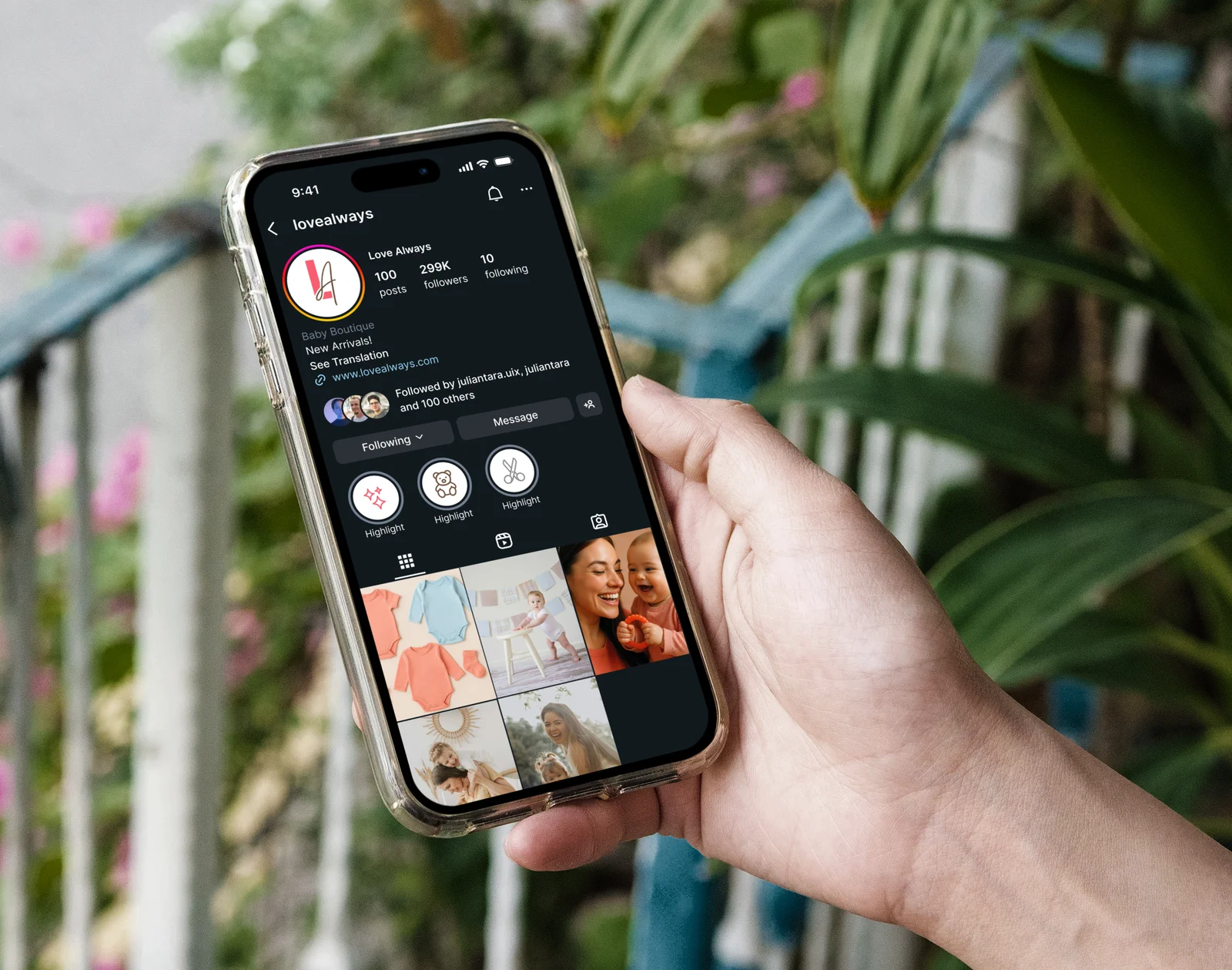 A hand holds a smartphone displaying the Instagram profile for Love Always Baby Boutique, showcasing baby products and community.